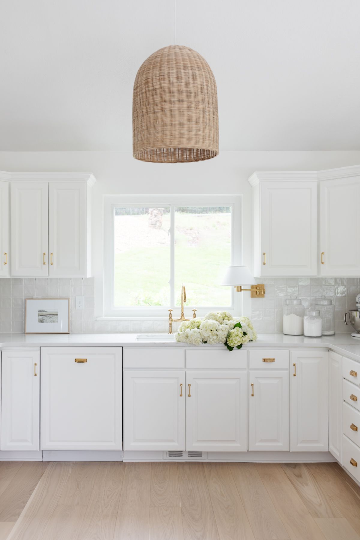 A white kitchen with glass canisters for baking supplies