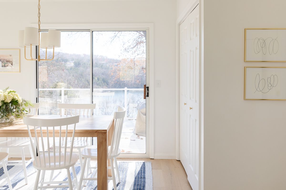 A dining room painted Benjamin Moore Chantilly Lace, lake views through the windows