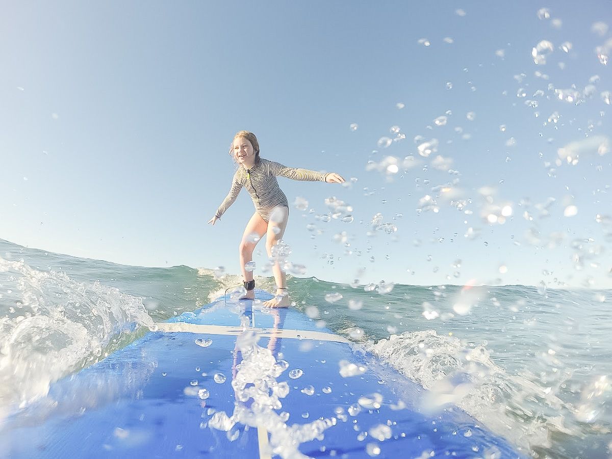 A young girl on a surfboard in the ocean