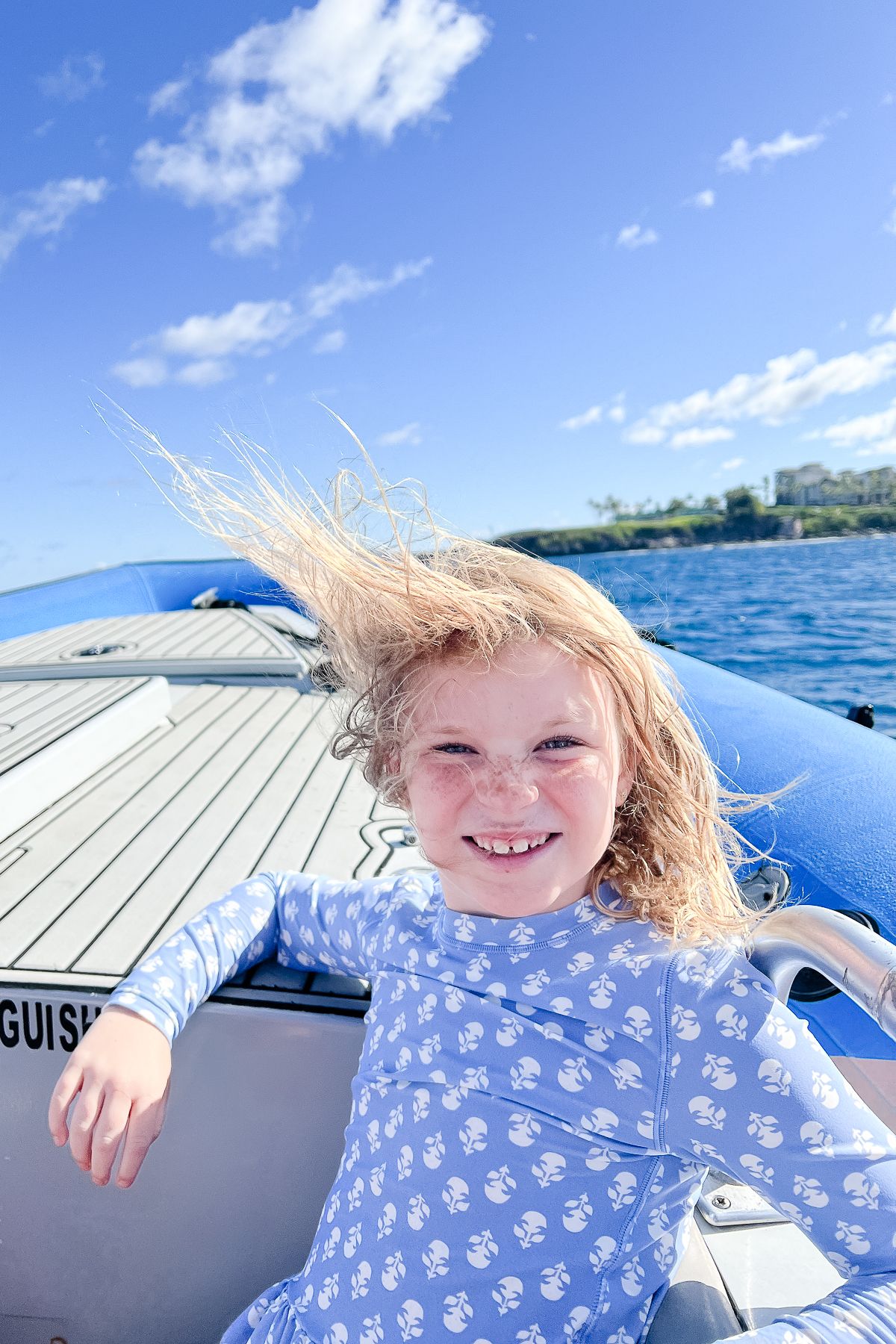 A little girl with blonde hair on a boat on Maui, the best Hawaiian island for kids