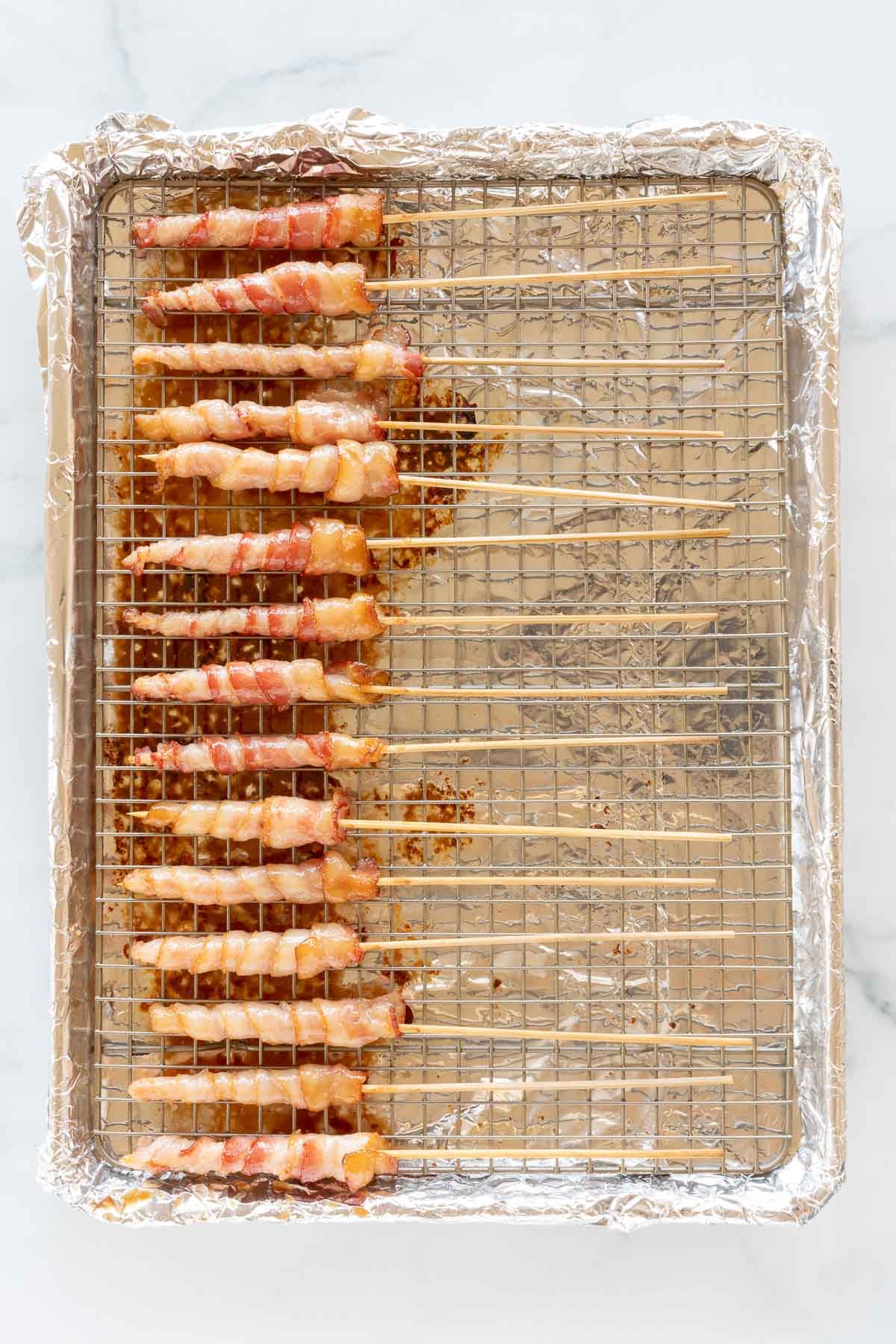 Caramel bacon on skewers, laid out on a baking sheet