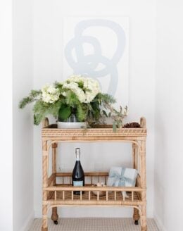 A rattan bar cart in the corner of a Chantilly White painted room