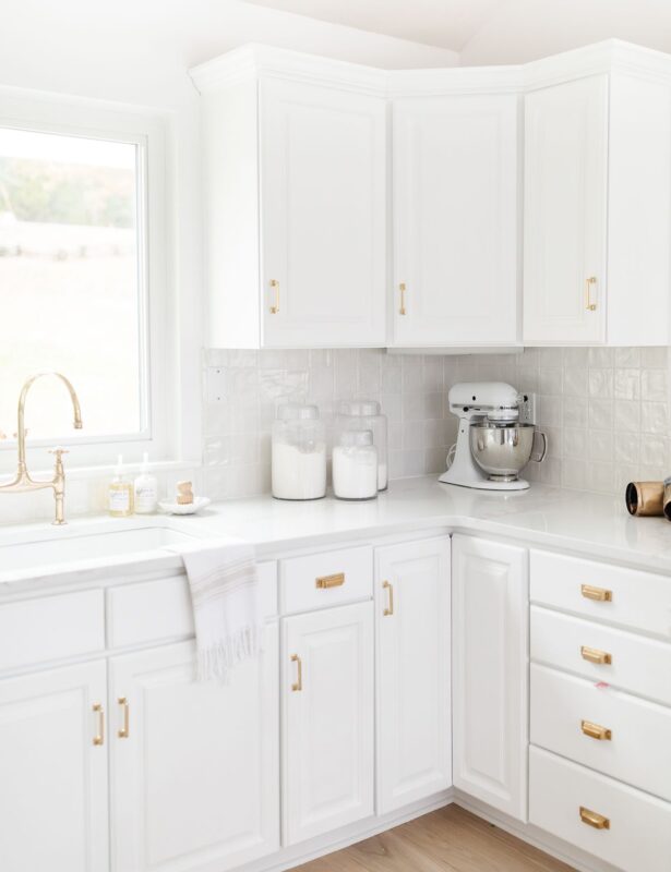 A white kitchen with white tile and a white tile grout color