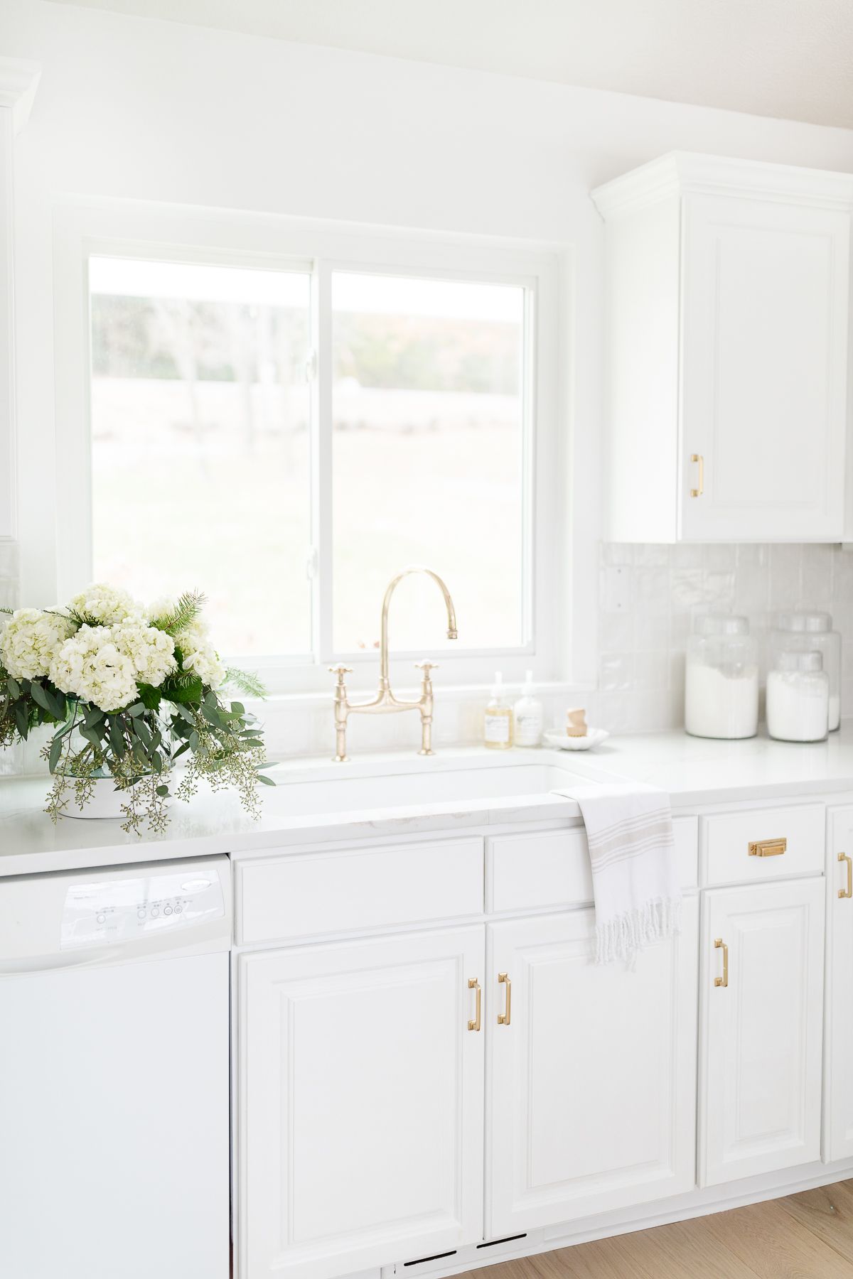 A white kitchen with white tile and a white grout color