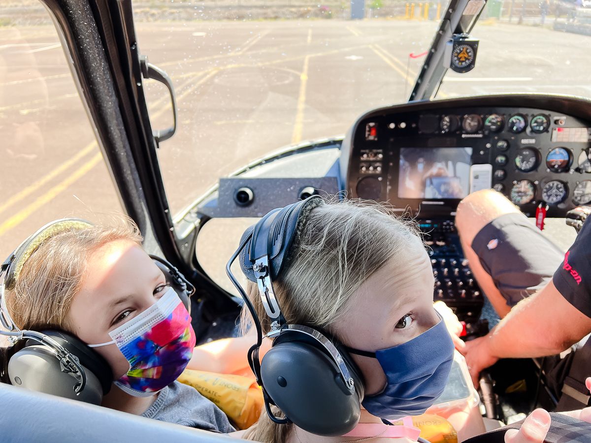 Two little girls wearing face masks on a helicopter on Maui, the best hawaiian island for families