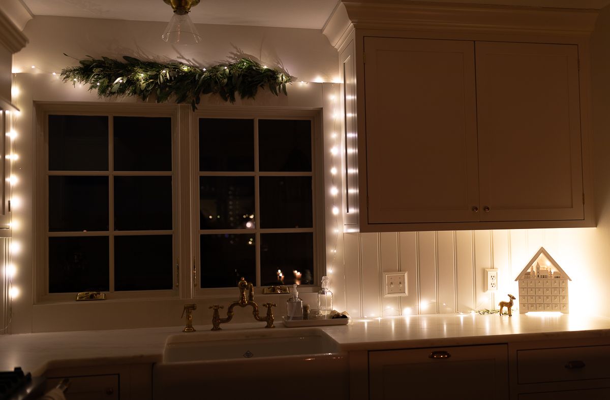 fairy lights in a kitchen window for a minimalist christmas touch