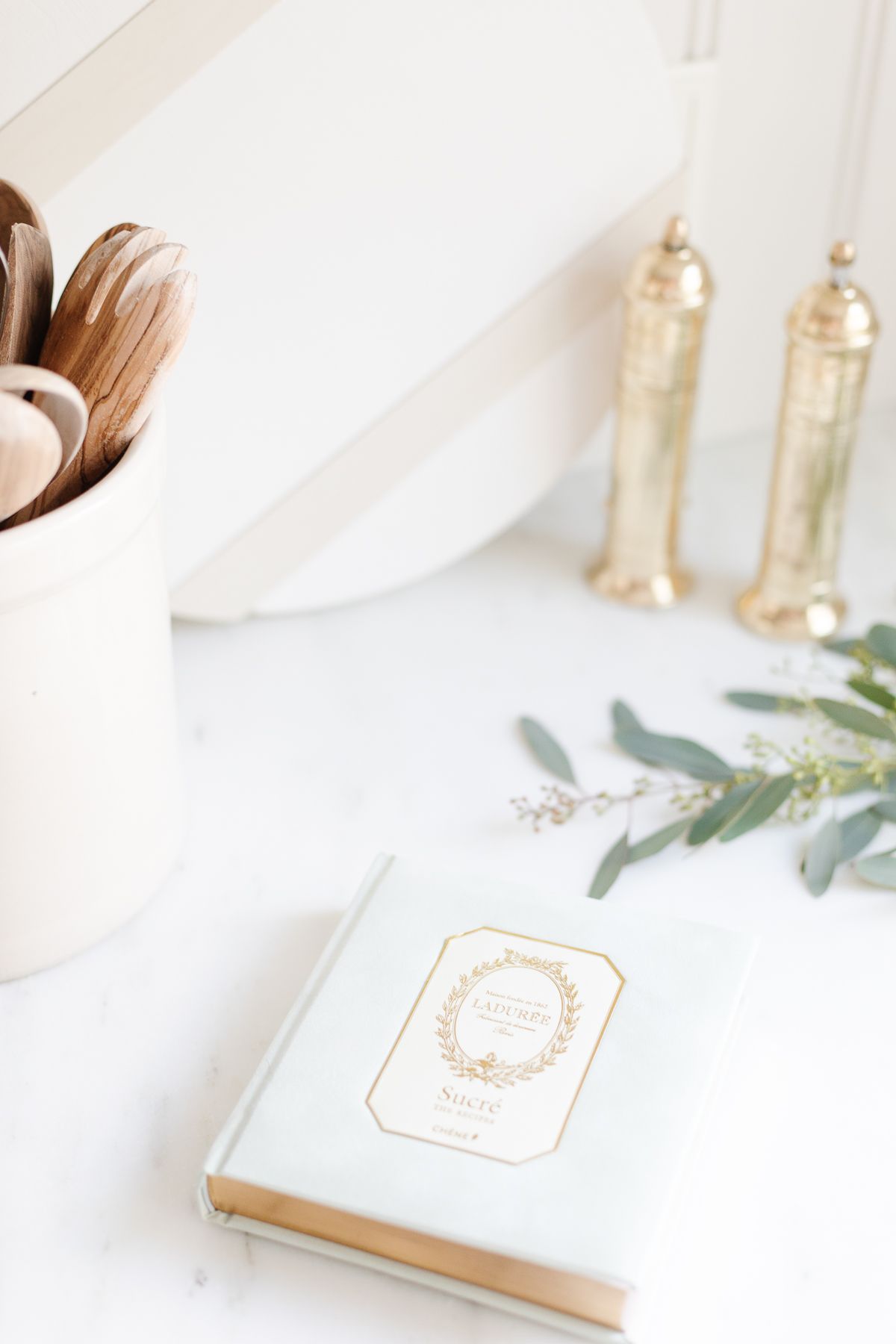 A kitchen decorated for the holidays with a white cookbook and touch of greenery