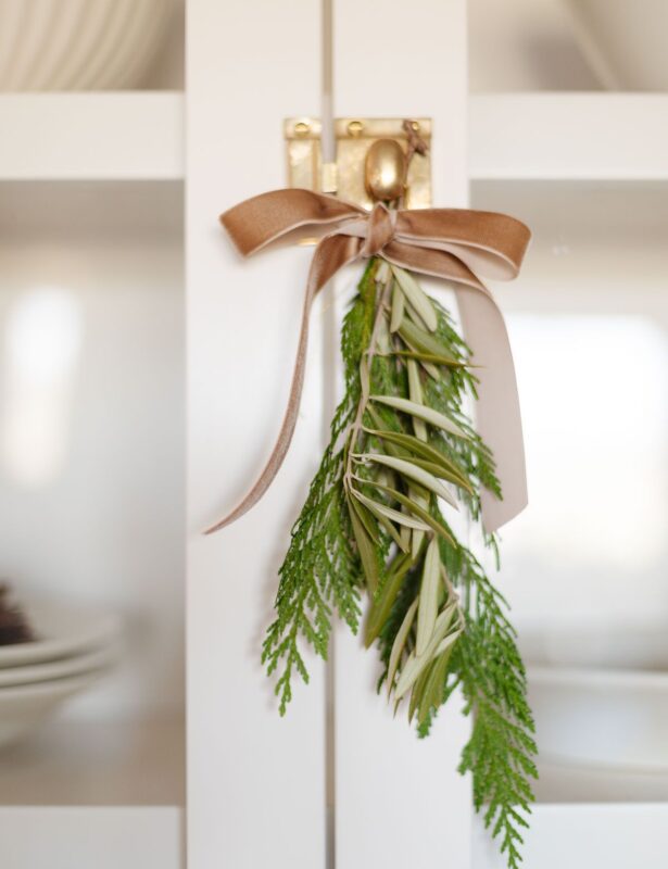 greenery tied onto a brass cabinet knob with a velvet ribbon