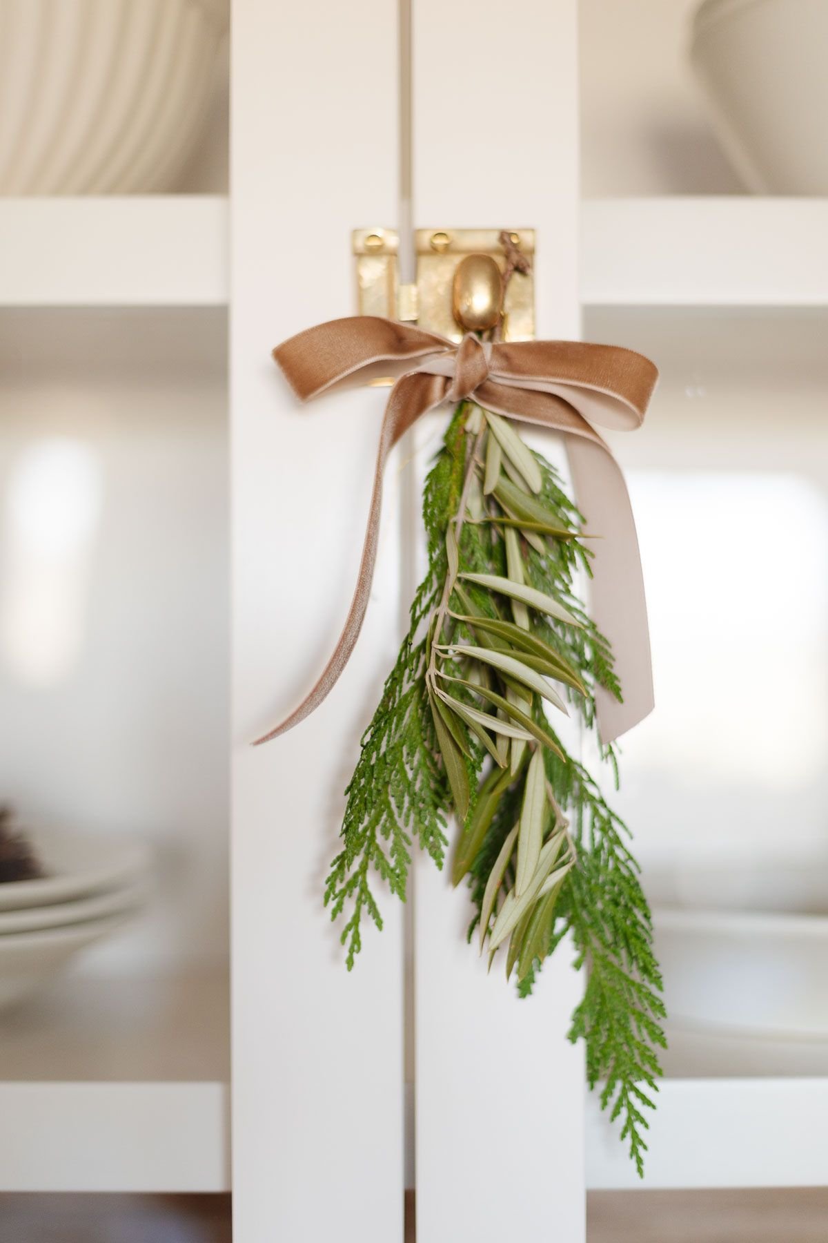 greenery tied onto a brass cabinet knob with a velvet ribbon
