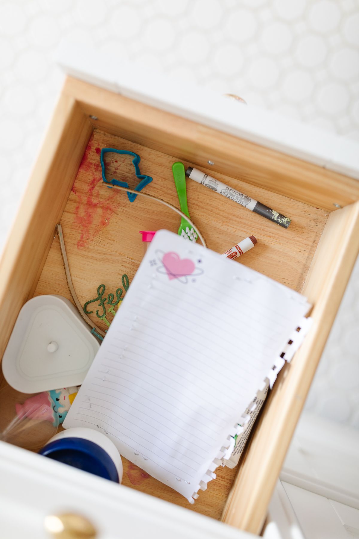 An open, messy bathroom drawer prior to an organization project