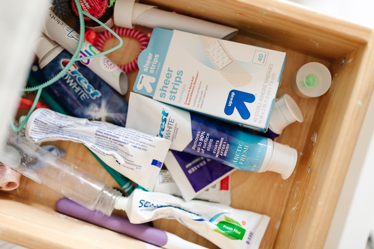 An open, messy bathroom drawer prior to an organization project