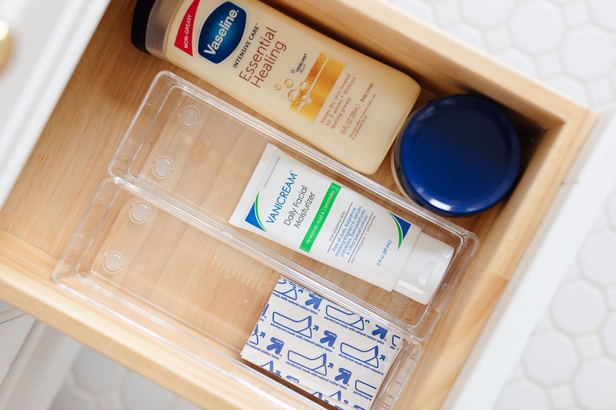 A bathroom drawer organizer with band aids, lotion and more