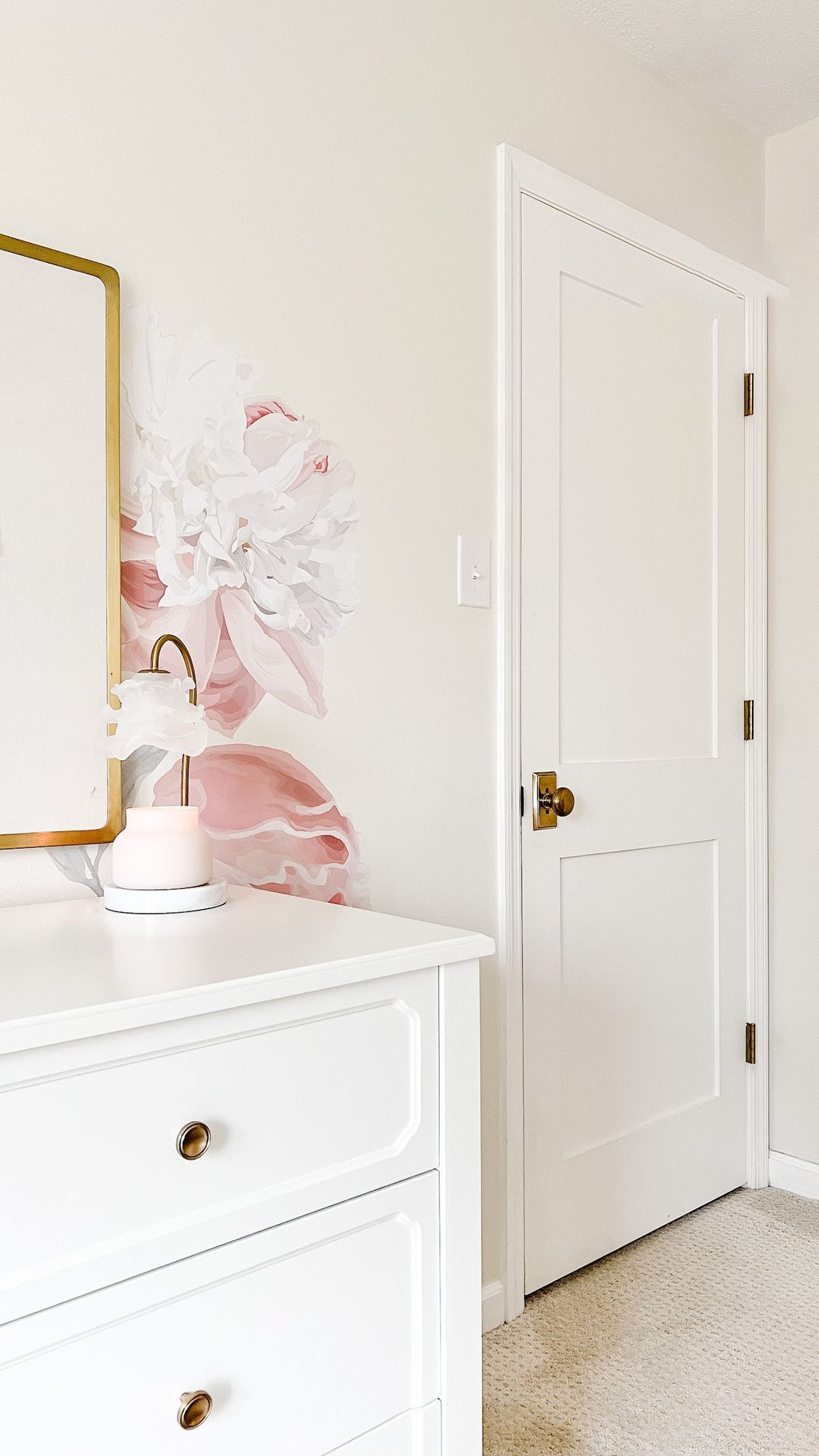 A girl's room with white furniture, a pink floral wallpaper, and a candle warmer Amazon gadget on the dresser. 