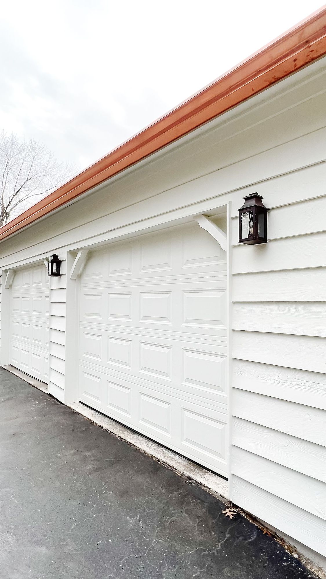 Copper gutters running over a white exterior garage