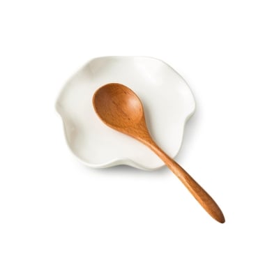 A wooden spoon sits on top of a white plate, adding to the kitchen counter organization.