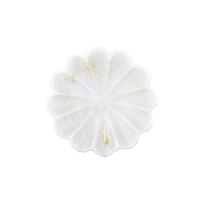 A white flower shaped plate on a kitchen counter.