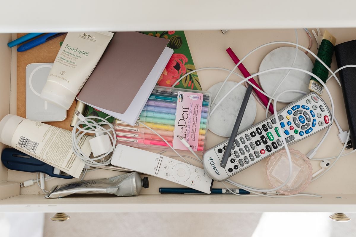 A messy drawer that opens before nightstand organization