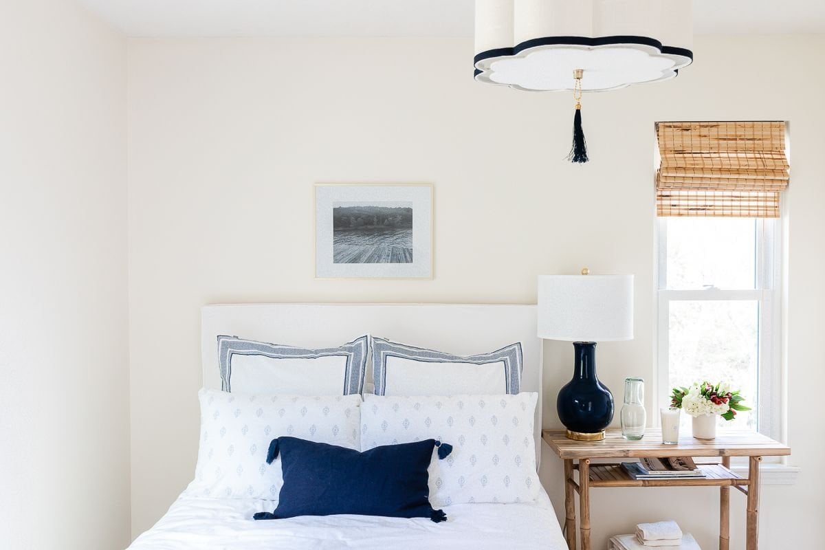 art over bed in a white and navy blue guest room