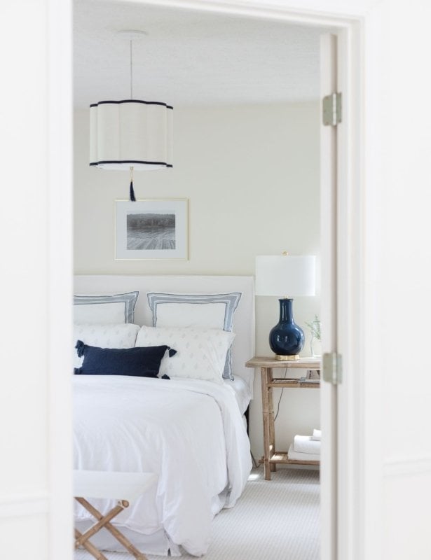 art over bed in a white and navy blue guest room