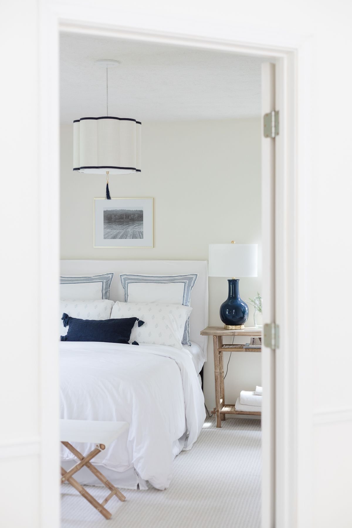 art over bed in a white and navy blue guest room