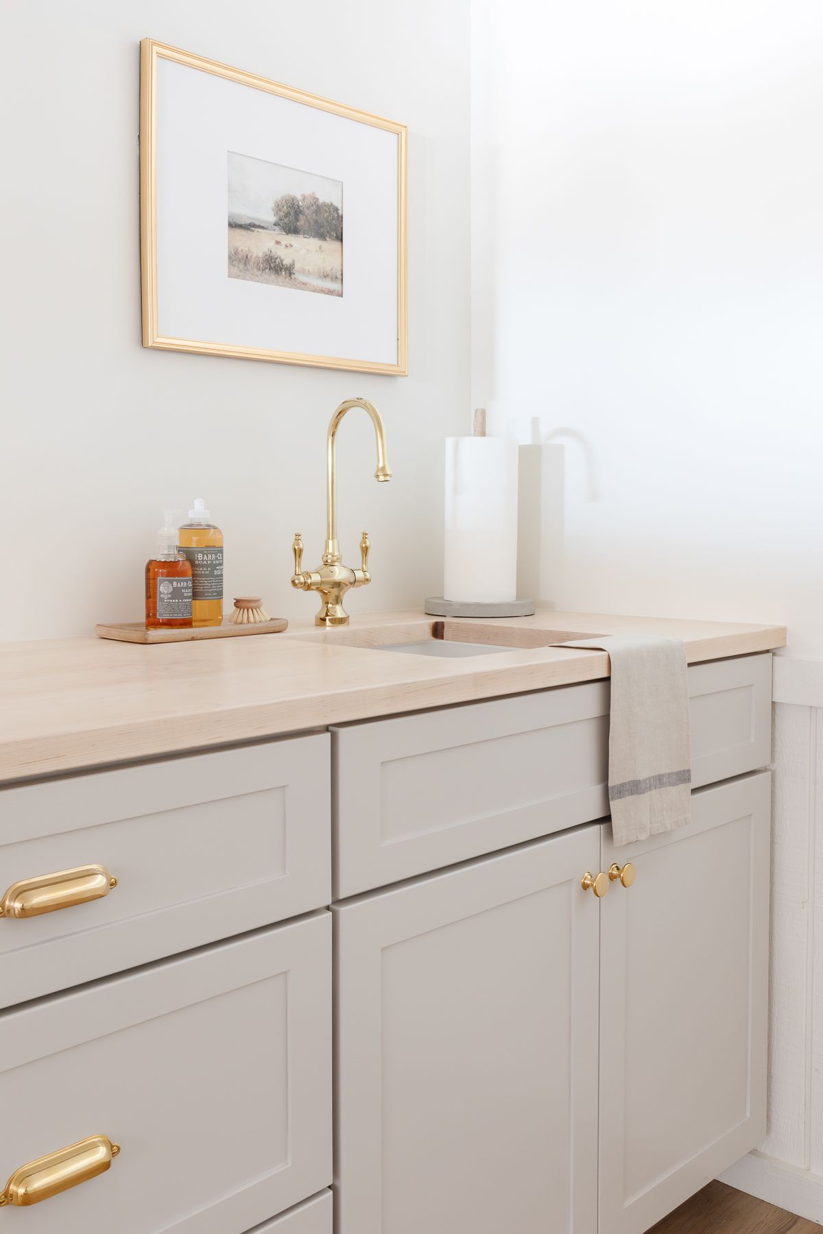 A basement wet bar with gray cabinets and butcher block countertops