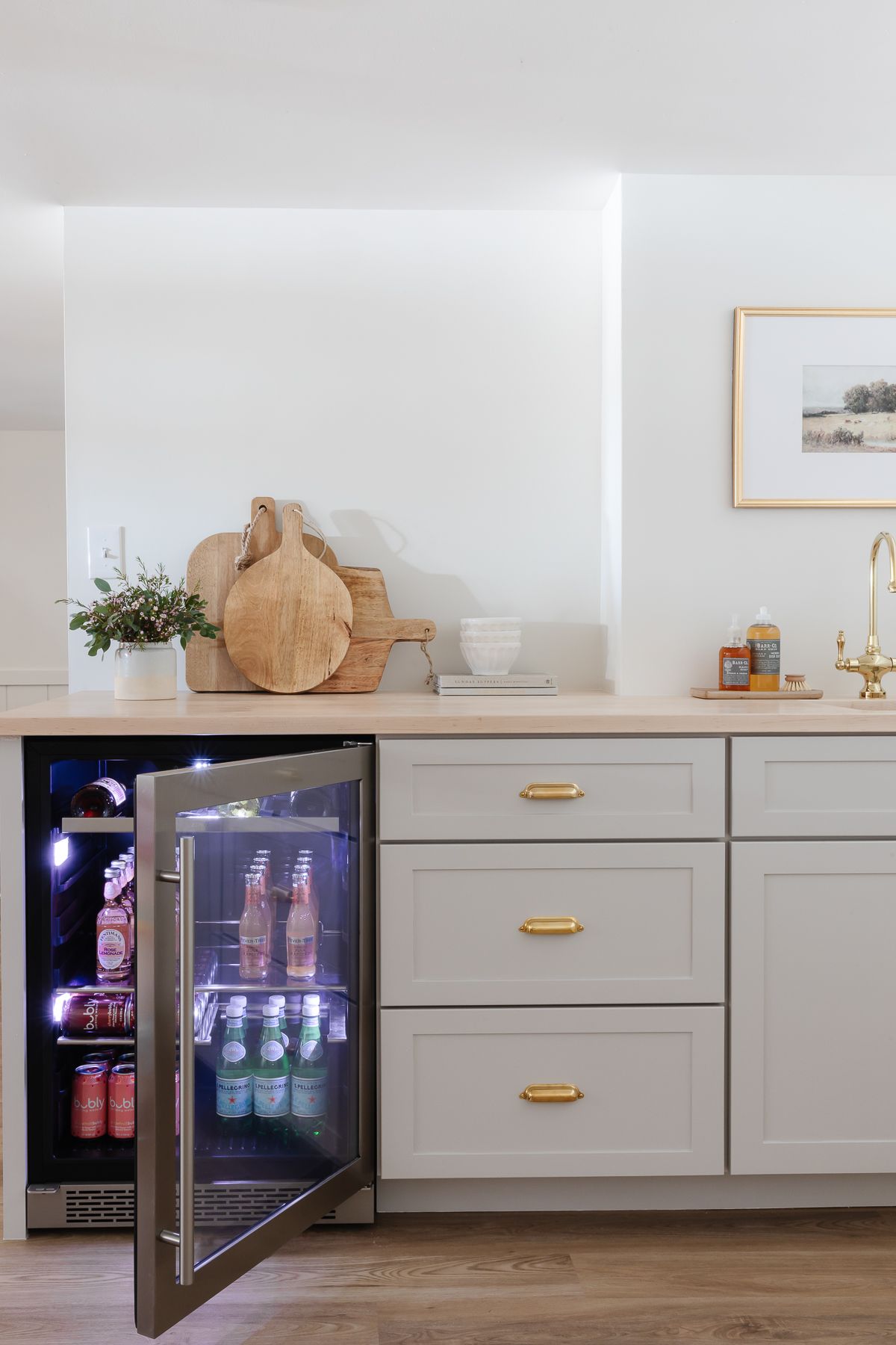 A basement wet bar with a beverage refrigerator and wooden cutting boards