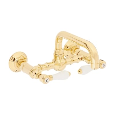A brass bathroom faucet with two handles on a white background.