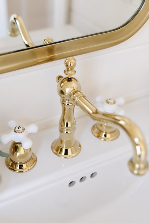 a bathroom with a gold faucet.
