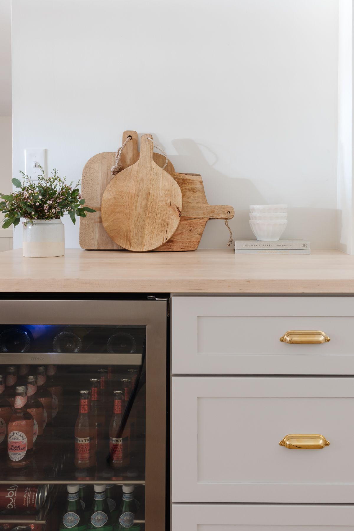 Wood countertops on a basement bar over a beverage refrigerator