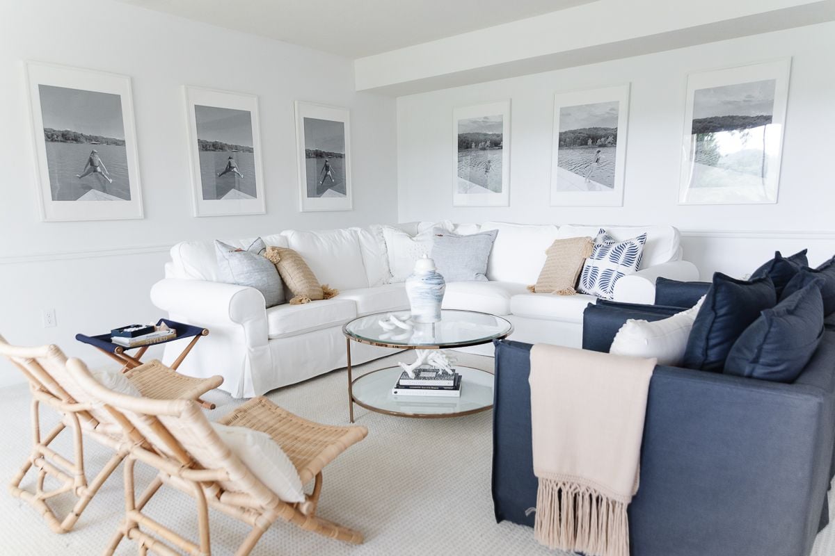 A white living room with navy chairs and textured rattan chairs