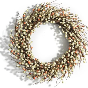 A charming spring wreath crafted from intertwined brown twigs and adorned with delicate white and orange berries.