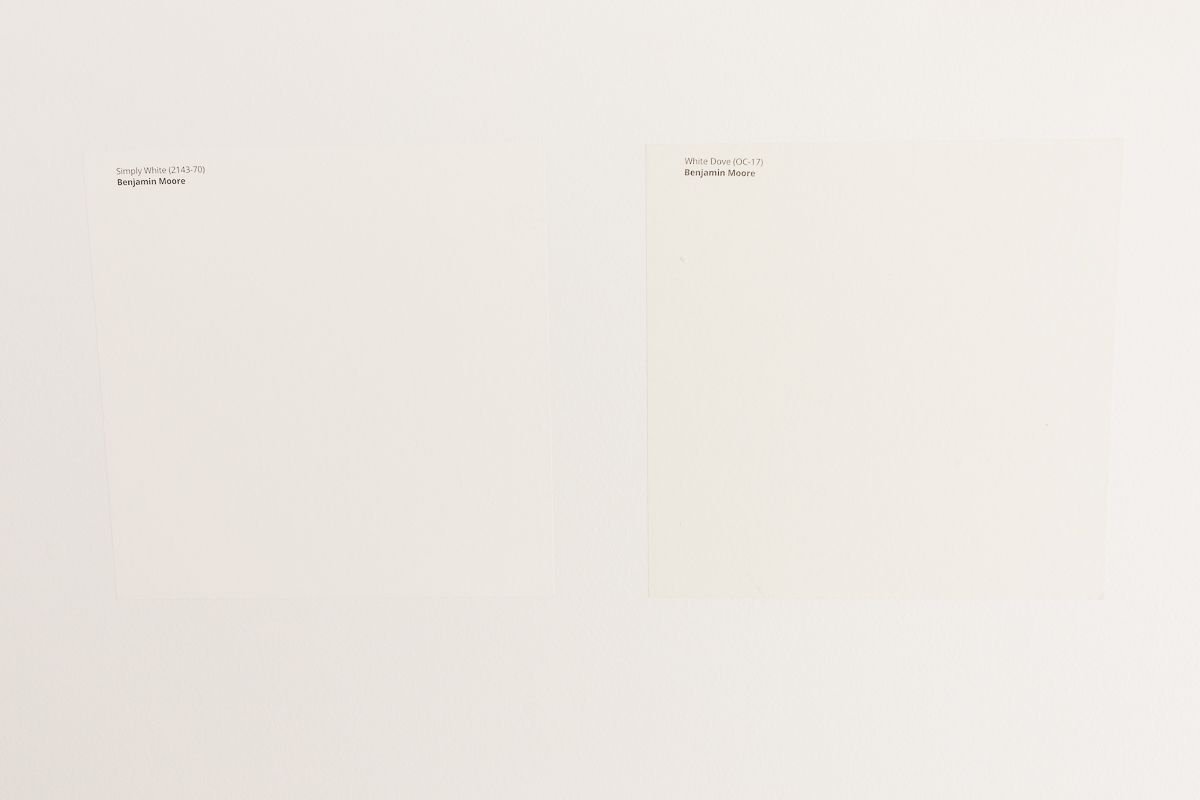 Two white Samplize paint samples stuck onto a white wall