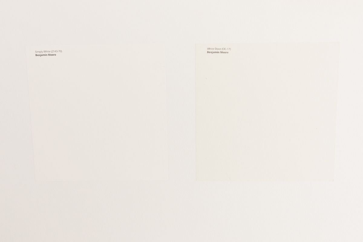 Two white Samplize paint samples stuck onto a white wall