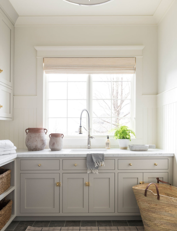 A laundry room with cabinets painted in Revere Pewter from Benjamin Moore, designed by Studio McGee