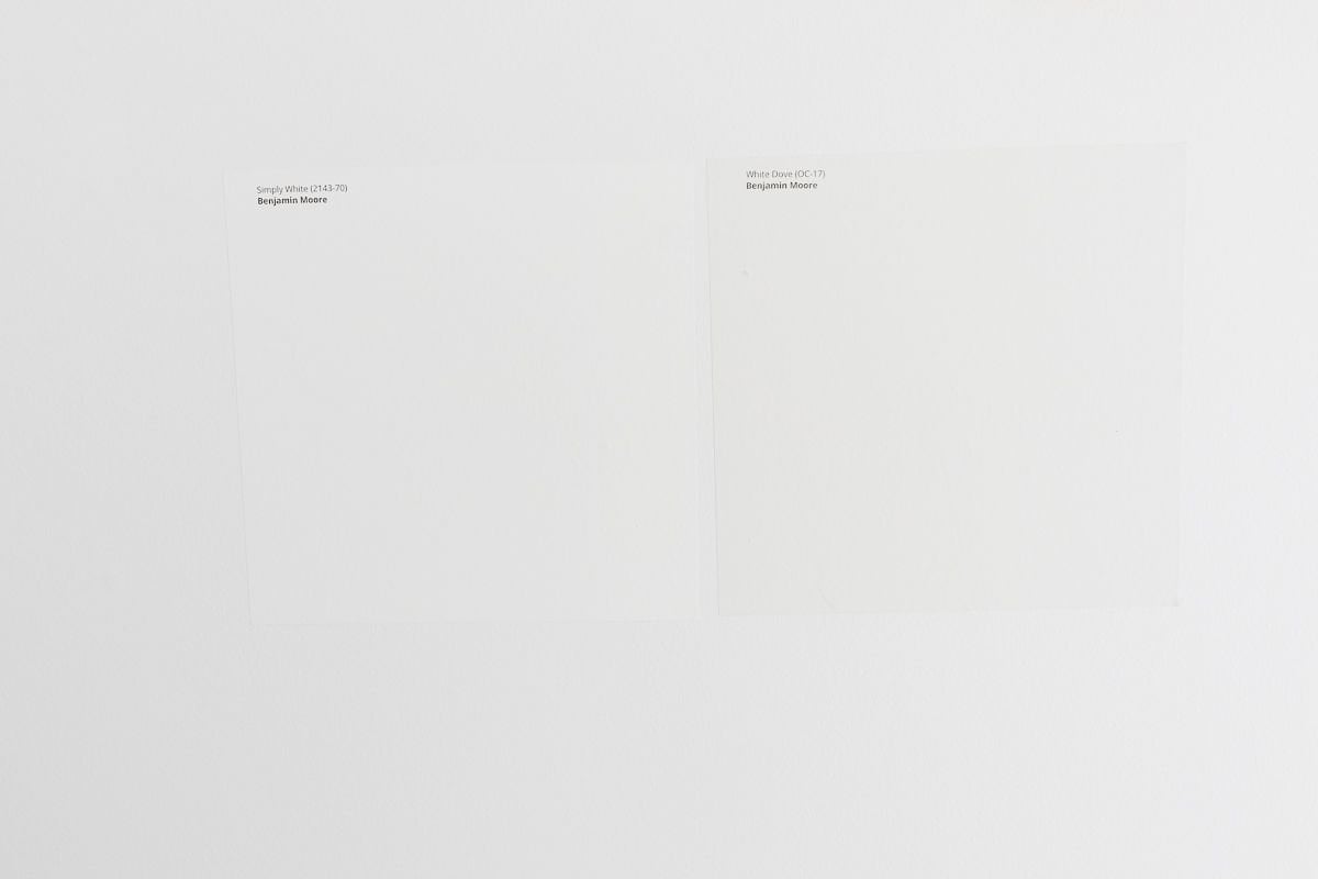 Two white Samplize paint samples stuck onto a white wall