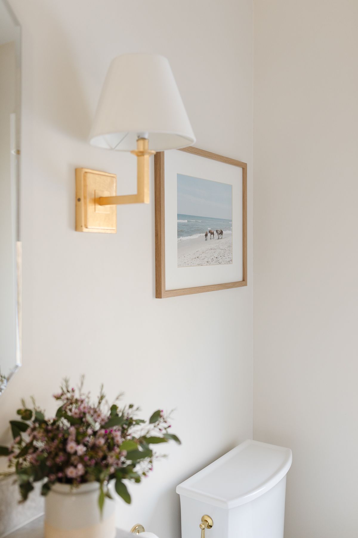 A home spa bath with a photo of wild horses on a beach on the wall