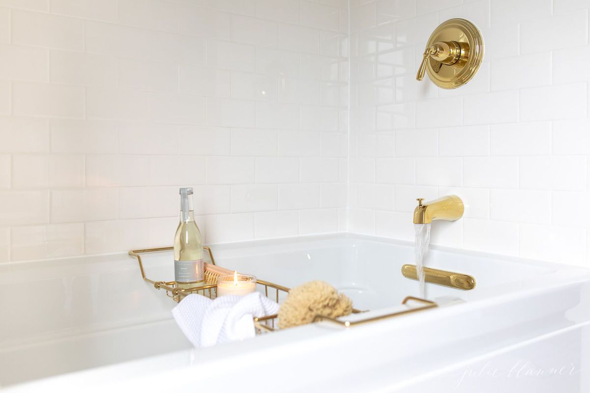 Air tub with brass bath fittings and a brass bath tray filled with relaxing spa treatments. 