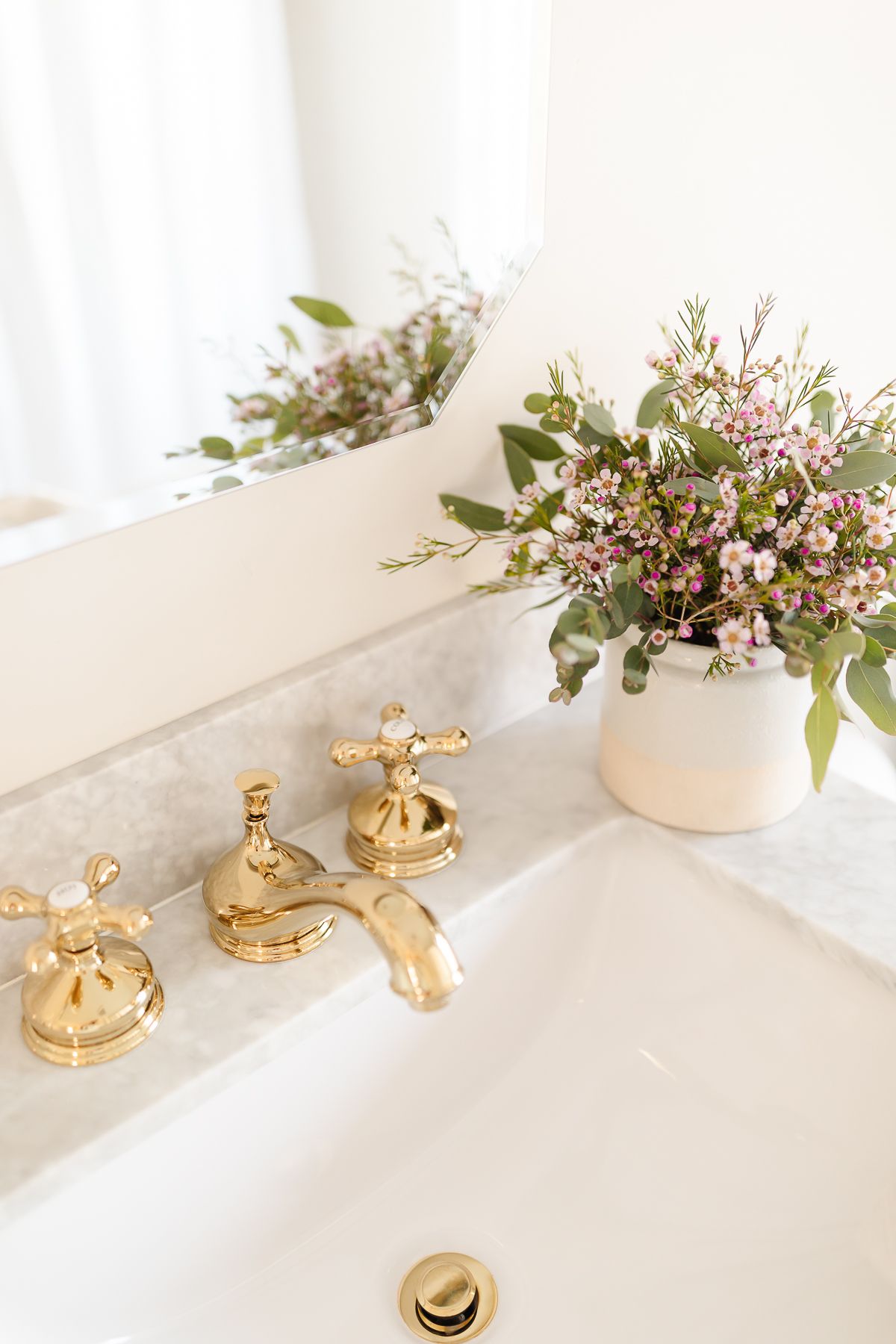 A brass faucet on a marble countertop in a bathroom