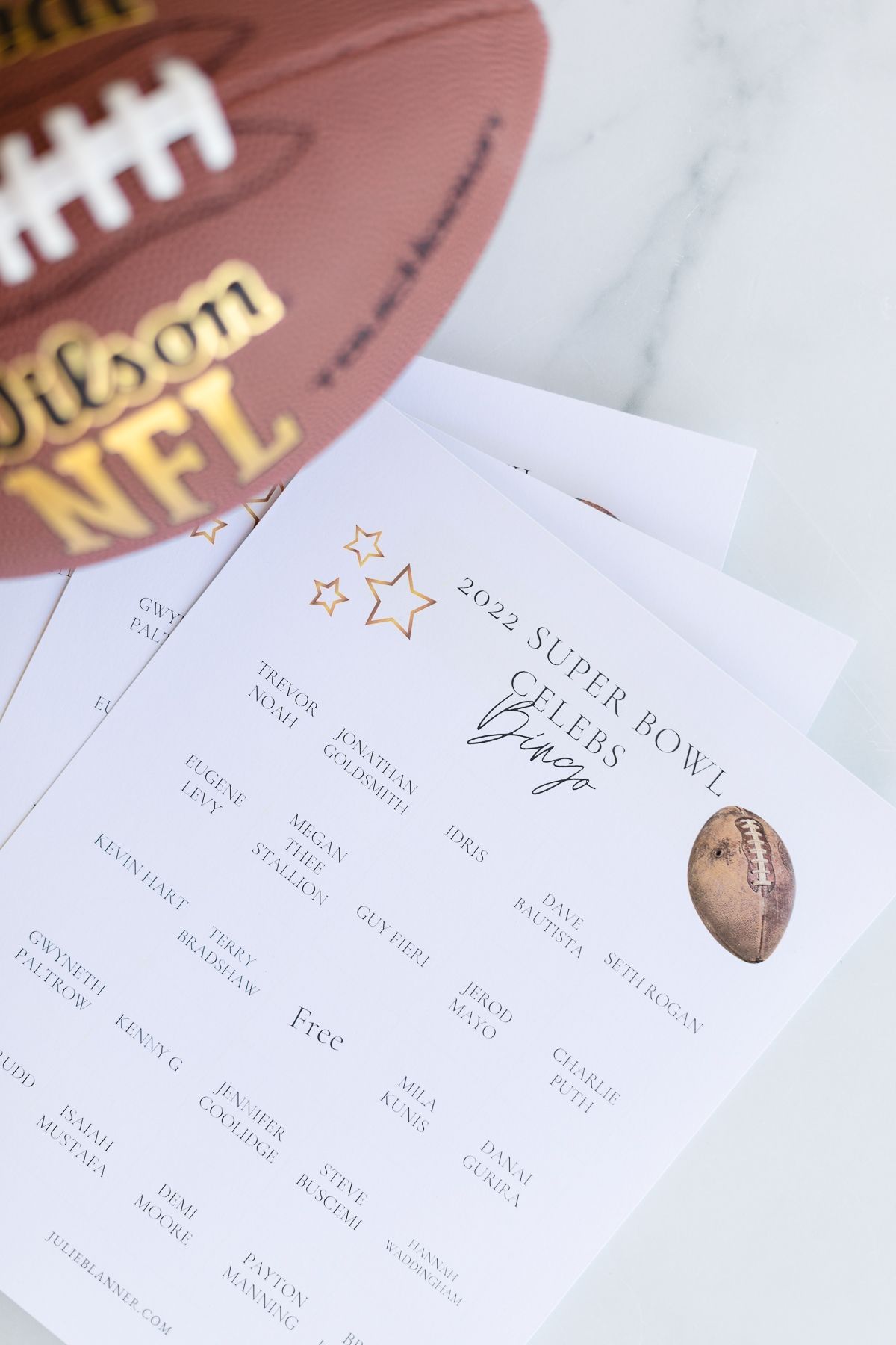 A free printable super bowl bingo game with a football in the background