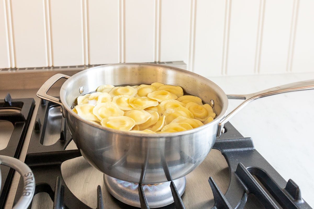 Tortelloni in a silver pot on a stove