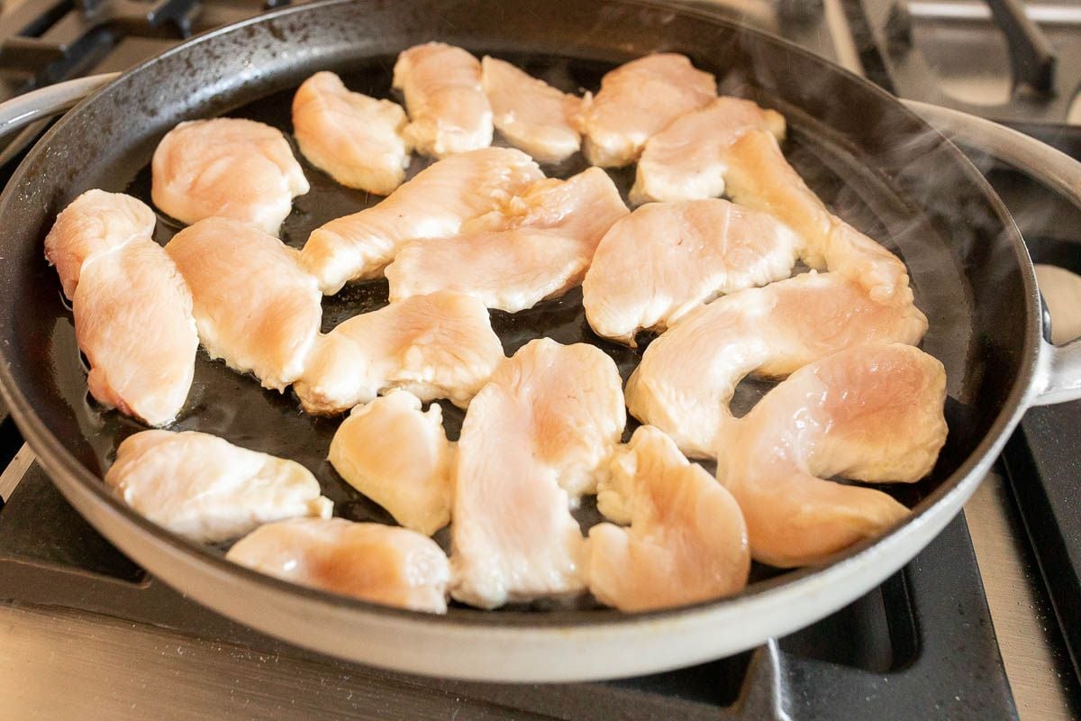Chicken tenders frying in a skillet
