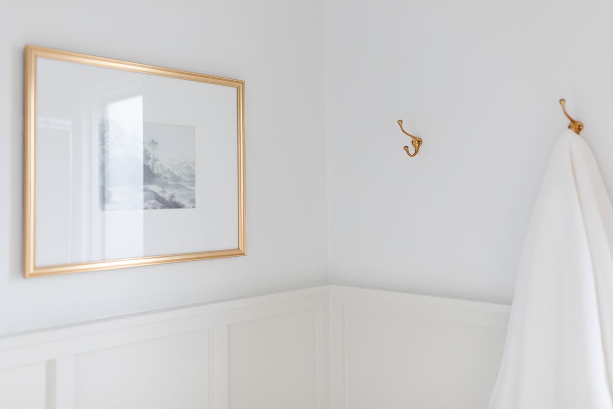 A small bathroom with board and batten painted in Classic Gray, and the upper walls painted in Benjamin Moore Decorator's White.