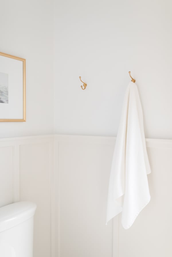 A Benjamin Moore Decorator's White bathroom with a towel hanging on the wall.