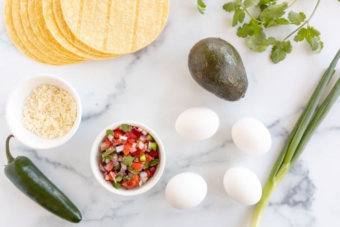 Breakfast taco ingredients laid out on a marble surface