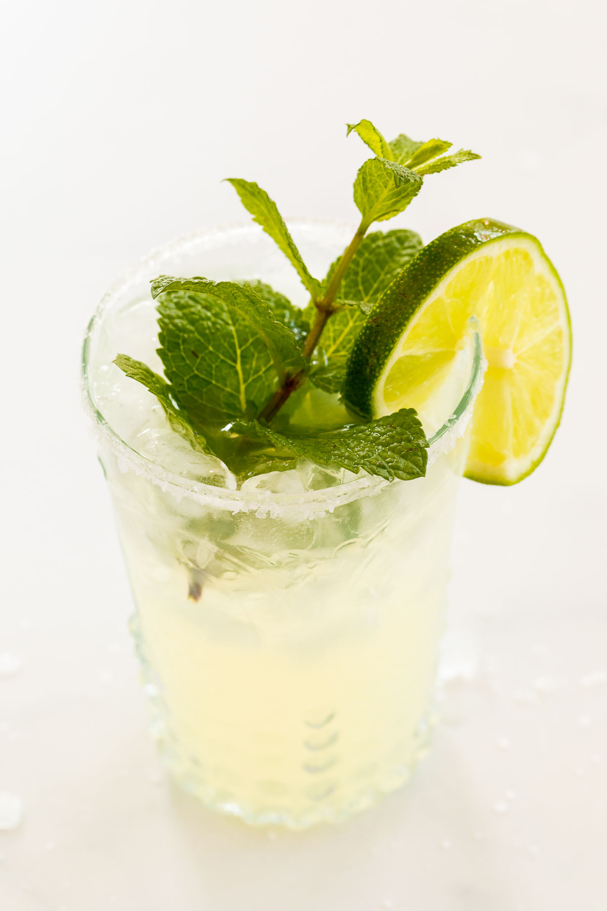 A mint margarita recipe in a clear glass, garnished with fresh mint.