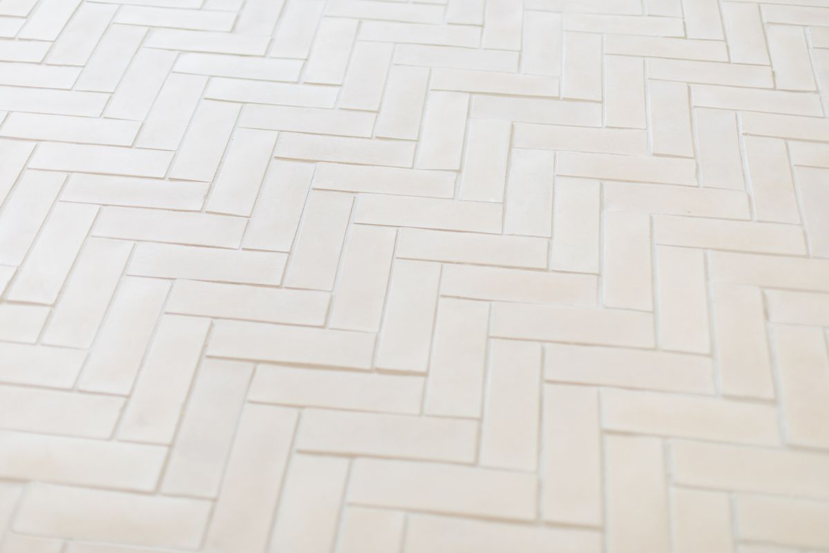 A herringbone floor laid with pale concrete tiles.