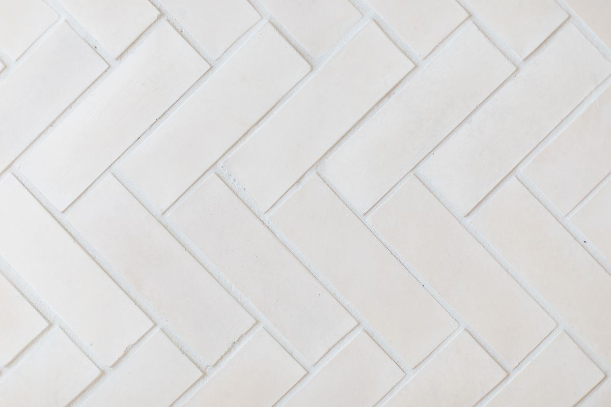 A herringbone floor laid with pale concrete tiles.