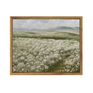 A framed painting of a field filled with white wildflowers under a cloudy sky, with distant green hills in the background—an elegant piece of amazon art perfect for adding tranquility to any space.