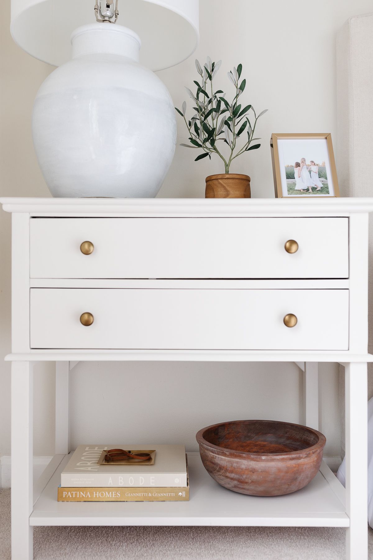 The bedside table is decorated with books, lamps, plants and pictures