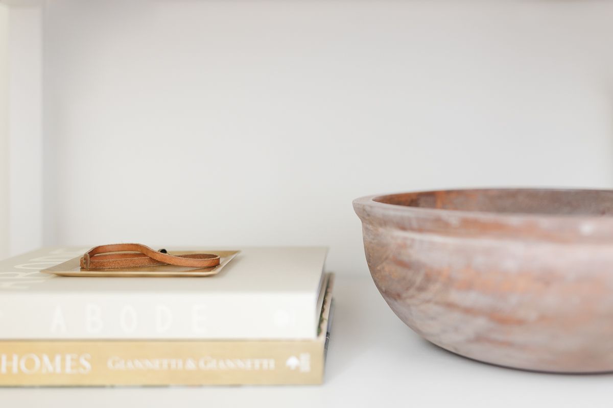 A bowl and books on a nightstand shelf